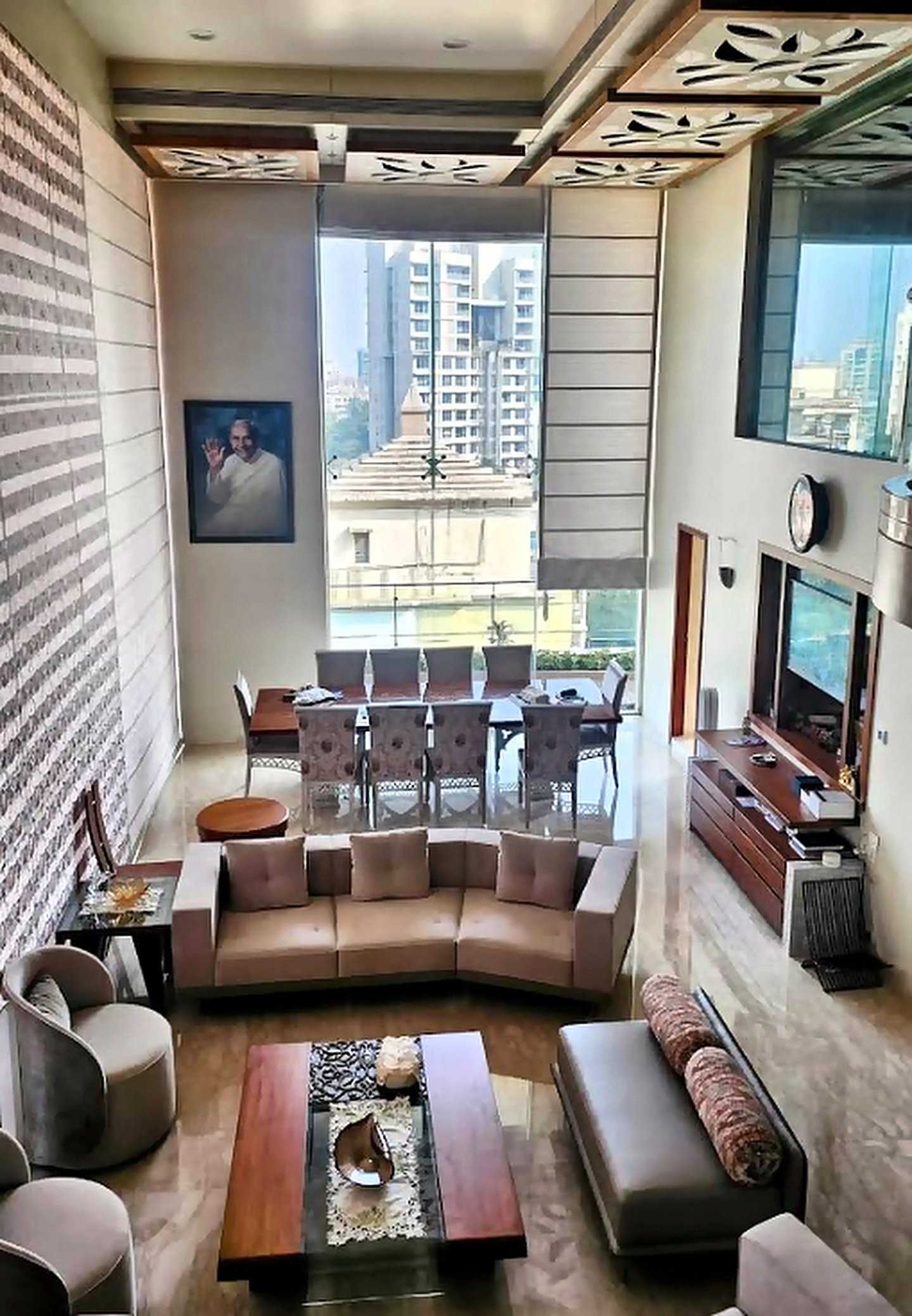Double-height duplex living room in Goregaon styled with Roman blinds and textured wall panels